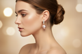 Woman wearing mauve pink pearl drop huggie hoop earrings